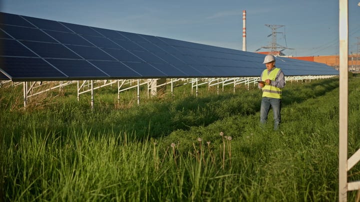 Engineer Reviews Solar Panels Under Clear Blue Sky