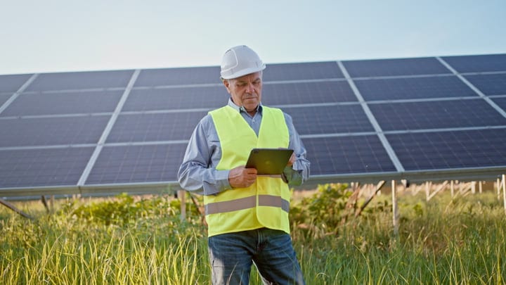 Engineer Reviews Solar Panel Data On Sunny Day