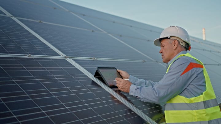 Experienced Solar Engineer Conducts Inspection On Bright Day