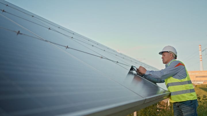 Engineer Conducts Detailed Solar Panel Inspection at Dusk