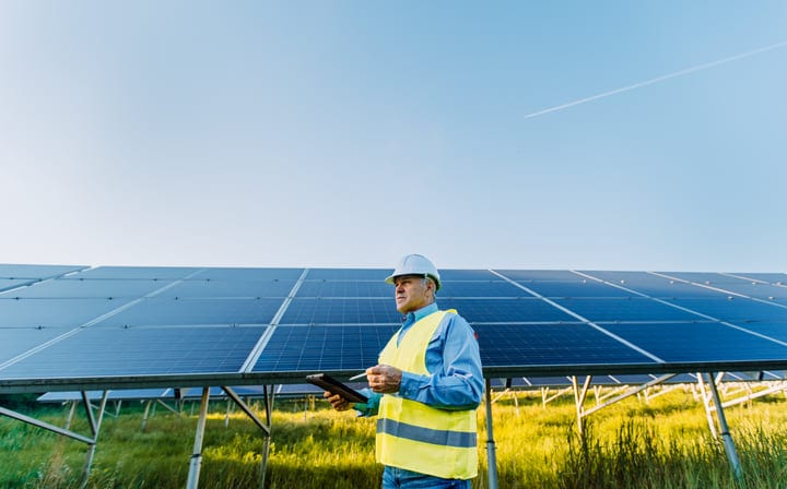 Engineer Conducts Solar Panel Inspection Under Clear Skies