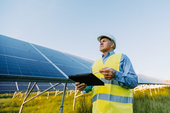 Focused Engineer Conducts Solar Panel Inspection On Site