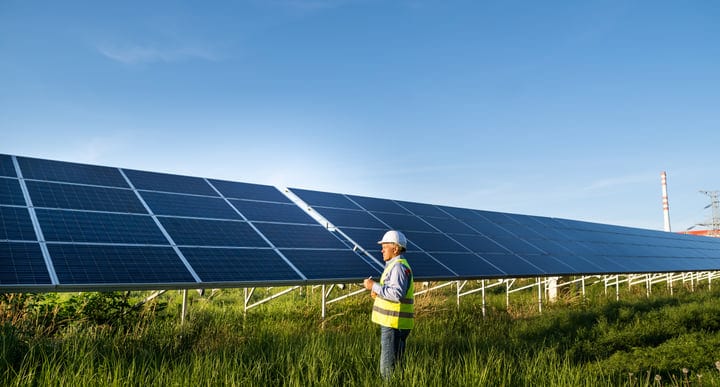 Solar Engineer Conducts Inspection Under Clear Blue Sky