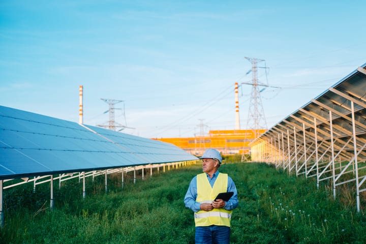 Engineer Surveys Solar Panels Under A Clear Sky