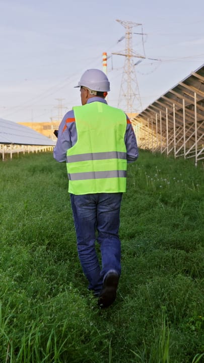 Engineer Strolls Through Solar Farm Under Clear Skies