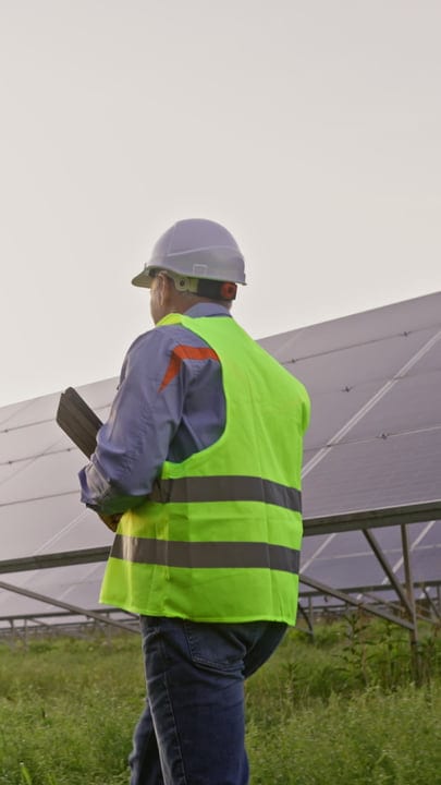 Engineer Conducts Solar Panel Inspection Under Grey Skies