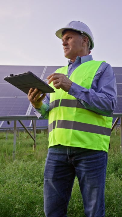 Engineer Conducts Solar Panel Inspection Under Clear Skies