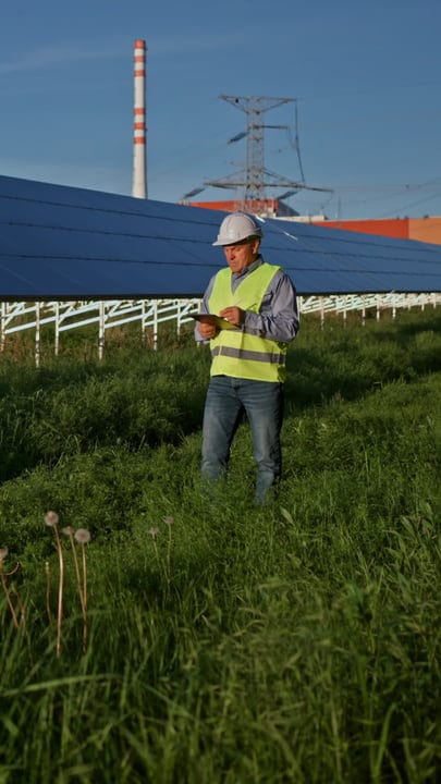 Engineer Evaluates Solar Panels Amidst Lush Greenery