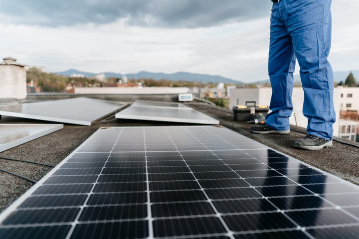 Engineer Inspecting Solar Panels Under Overcast Skies