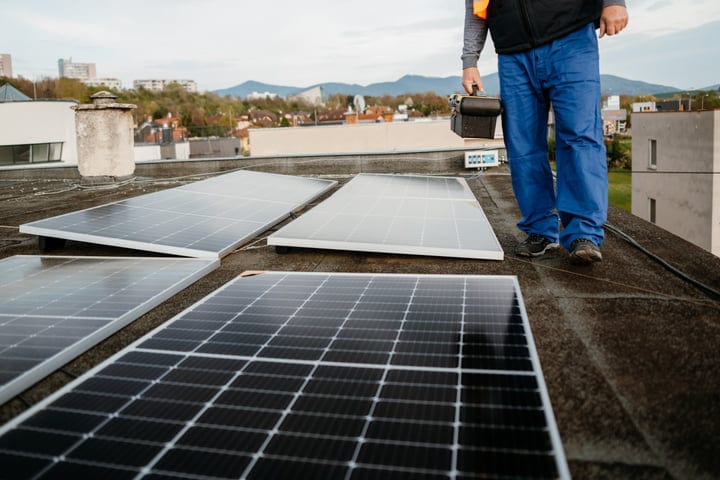 Engineer Inspecting Solar Panels On A Rooftop With A View