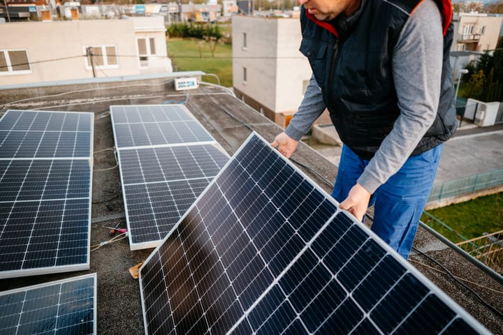 A Solar Engineer Adjusts Panels On A Rooftop
