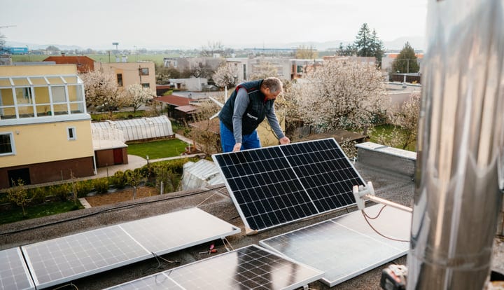 Engineer Adjusts Solar Panels On A Spring Rooftop