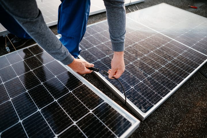 Hands Align Solar Panels Under Bright Sunlight