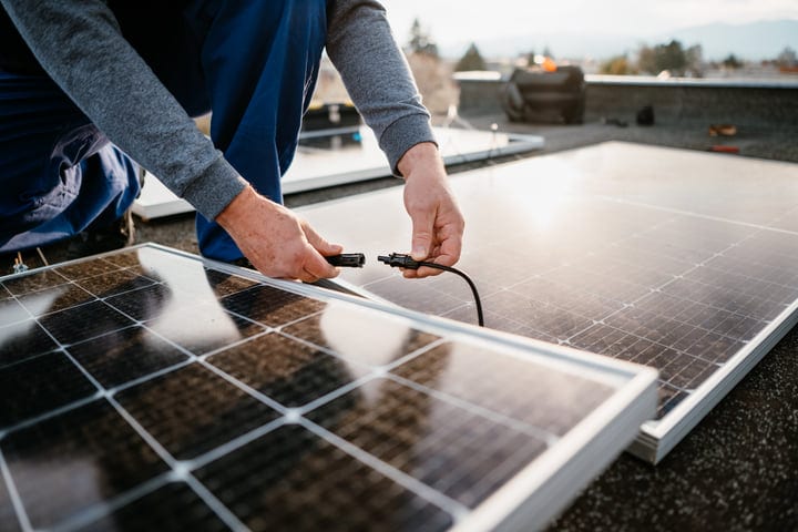 Connecting Solar Panels Under A Clear Sky On Rooftop