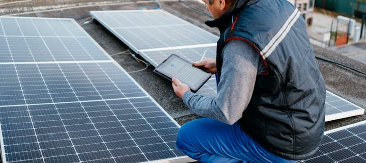 Engineer Analyzes Solar Panel Data On Rooftop