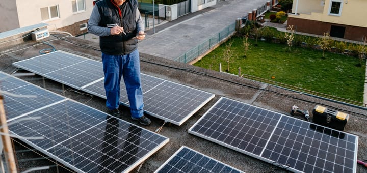 Focused Engineer Inspects Solar Panels On Rooftop
