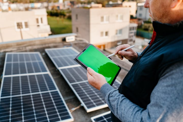 Engineer Analyzing Solar Data with Tablet on Rooftop