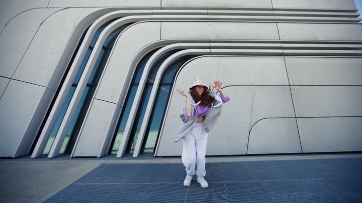 Joyful Street Dance Against Modern Architectural Backdrop