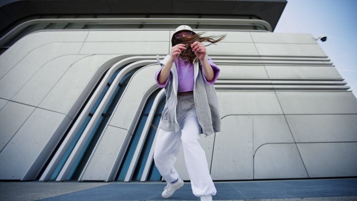 Urban Dancer Moves With Energetic Grace Against Modern Backdrop