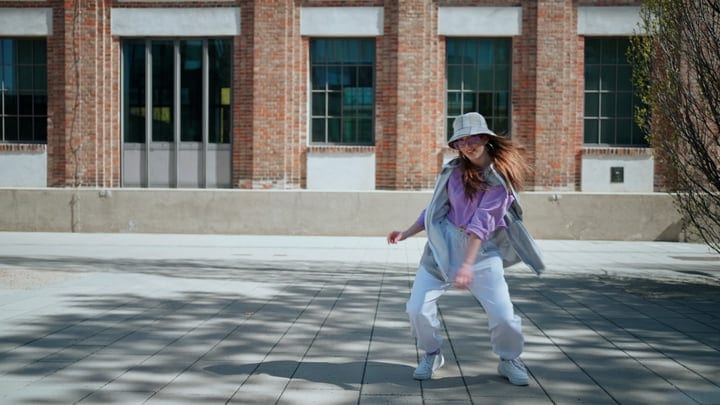 Street Dancer Twirls in Sunlit Urban Landscape