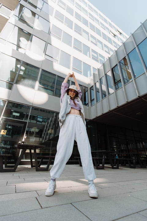 Urban Dancer Expresses Joy Under Sunlit Skyscrapers