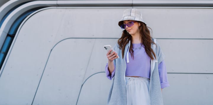 Trendy Young Woman Checking Her Phone on Urban Street
