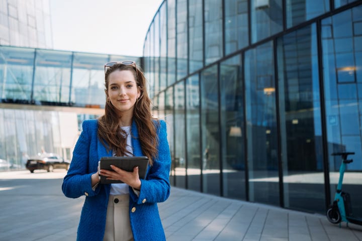 Confident Business Professional Stands Amid Glass Skyscrapers