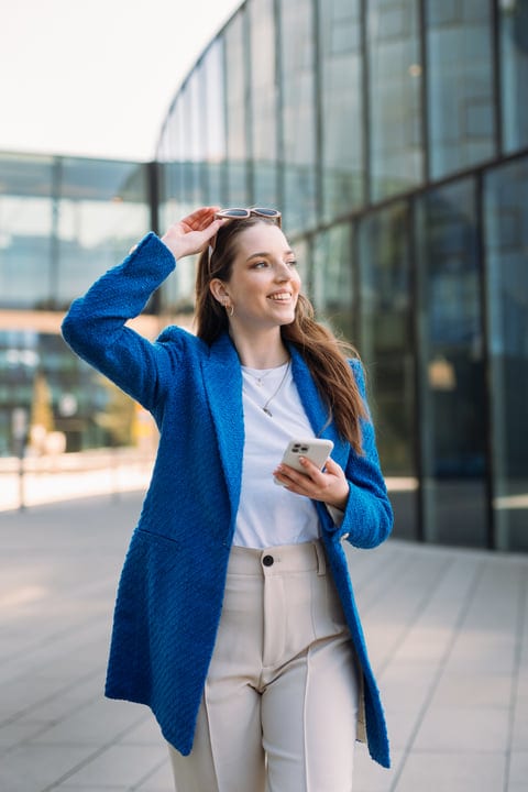 Young Woman Strolling Joyfully With Her Smartphone