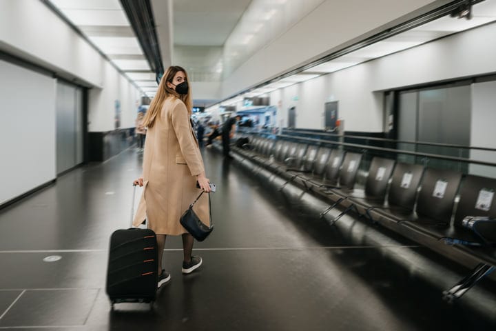 A Traveler Navigates Through An Empty Airport Terminal