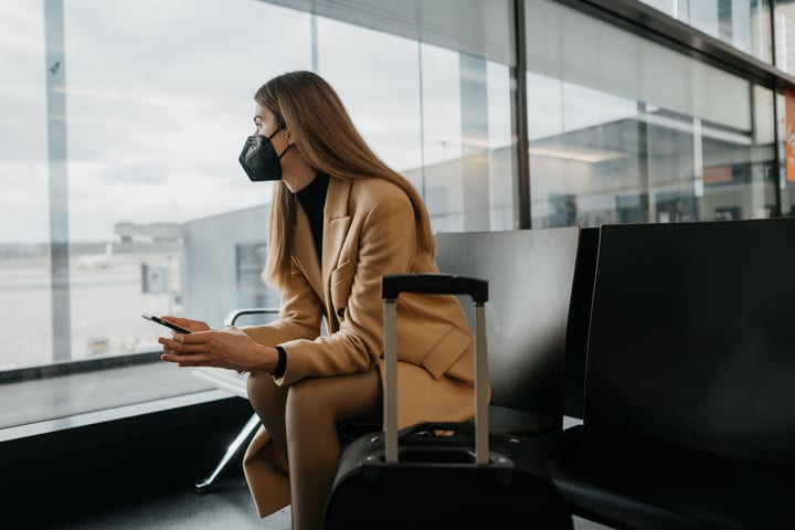 Traveler Relaxes In Airport Lounge With Phone In Hand