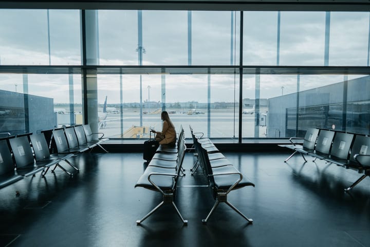 Reflective Traveler Awaits Flight In Quiet Terminal