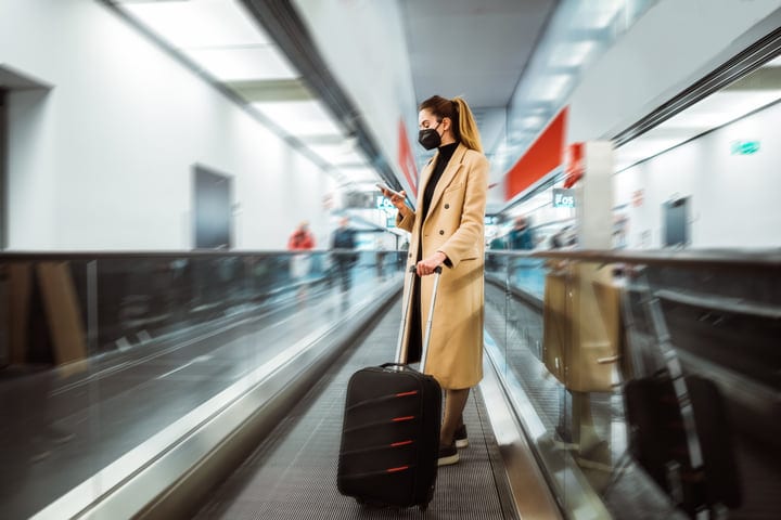 Traveler On Airport Walkway Checking Her Phone