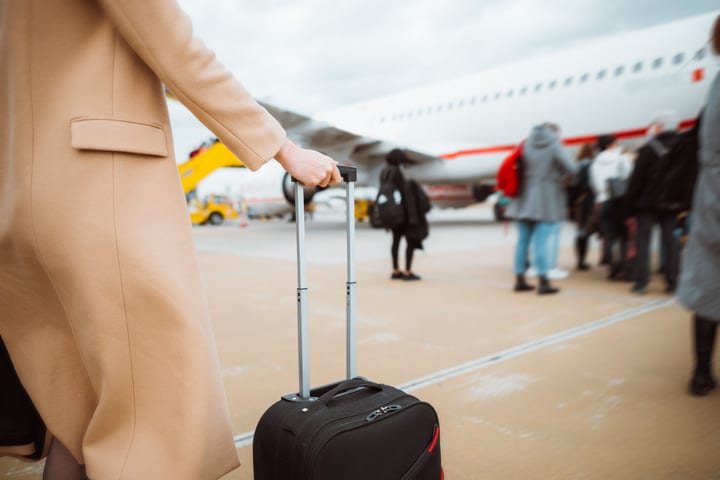 Traveler With Suitcase Prepares For Boarding At Airport
