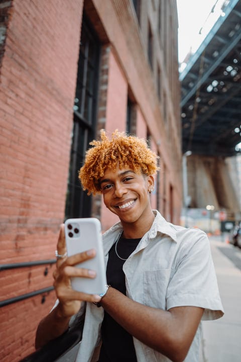 Smiling Youth Captures Urban Moment With Smartphone