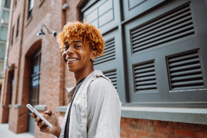 Young Urban Explorer Smiling On A Vibrant City Street