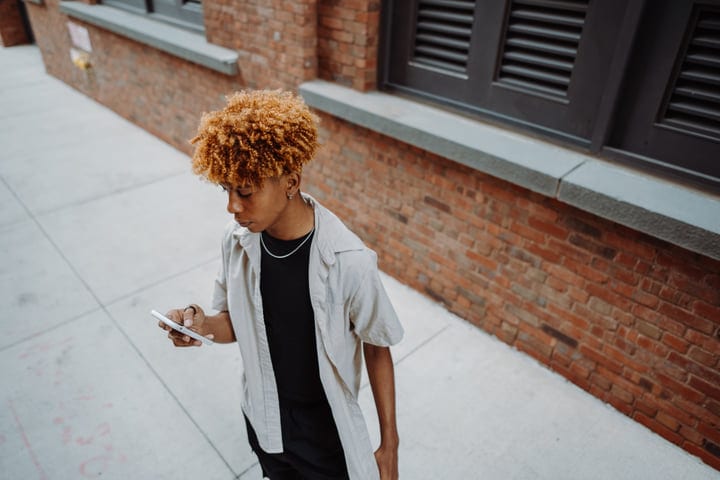 Young Adult Navigates Urban Life With Smartphone In Hand