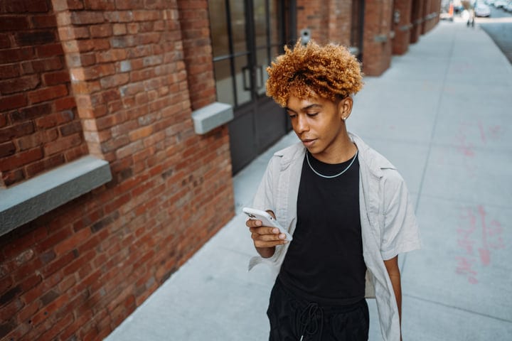 Youth Immersed In Digital World On A City Stroll