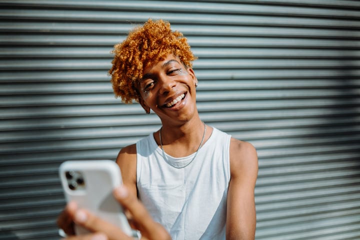 Smiling Youth Takes a Selfie in Bright Urban Setting