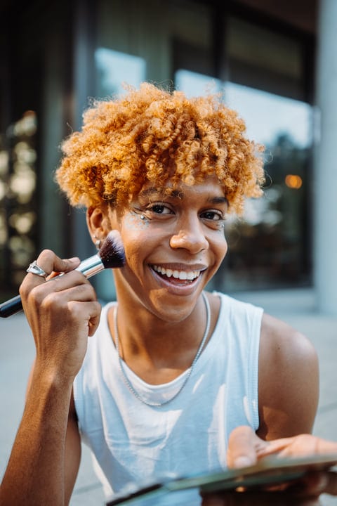 Laughing Youth Applies Makeup On A Bright NYC Street