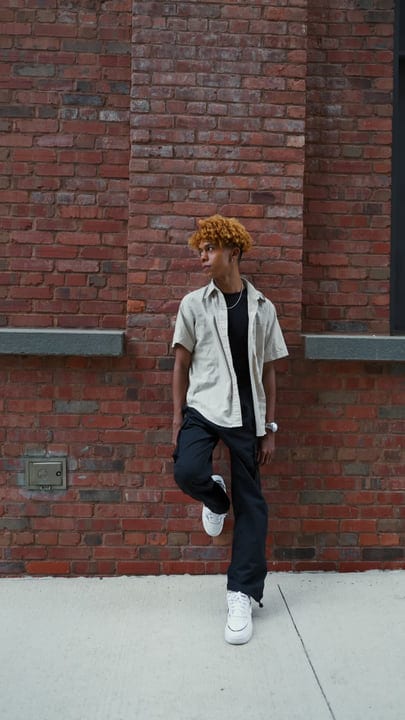 Youthful Reflection Against A Vibrant Urban Brick Wall