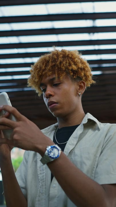 Focused Youth Engages With Smartphone In Urban Setting
