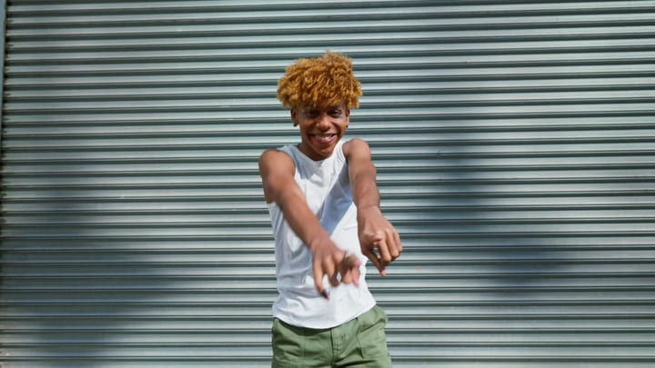 Urban Youth Expressing Joy Against a Metal Shutter