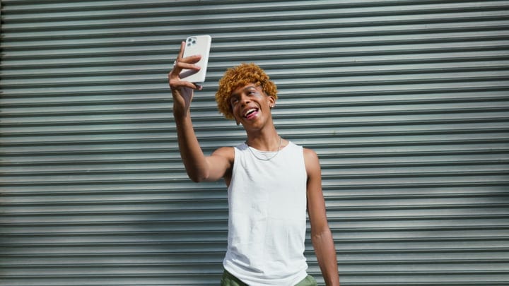 Joyful Teen Captures Selfie Against Urban Backdrop