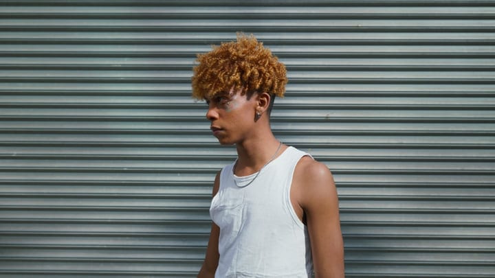 Urban Youth Contemplates Against Textured Metal Backdrop
