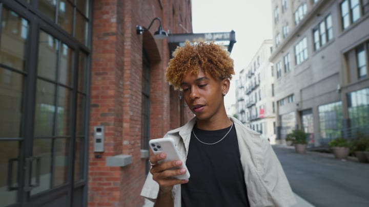 A Young Man Engages With His Phone On A New York Street