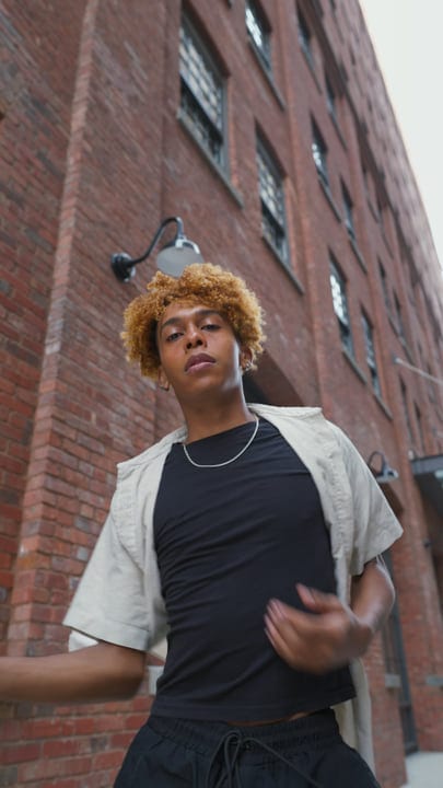 Confident Youth Walks Through New York Brick Alley
