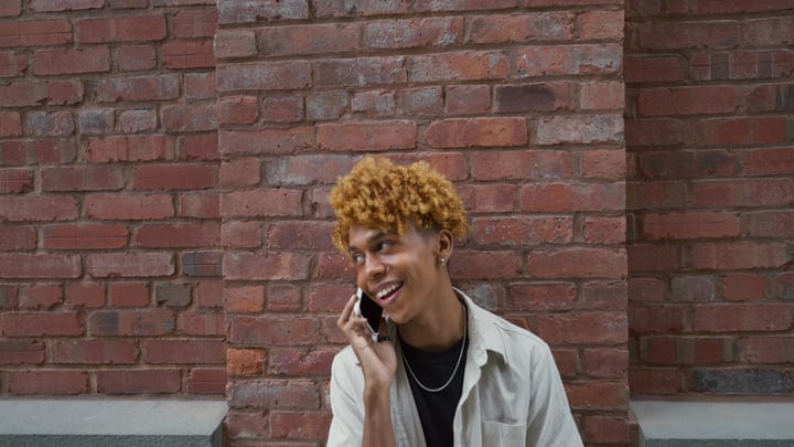 Young Urbanite Laughing Against A New York Brick Wall