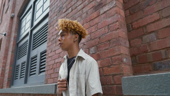 Contemplative Youth Against Brick Wall In Urban NYC
