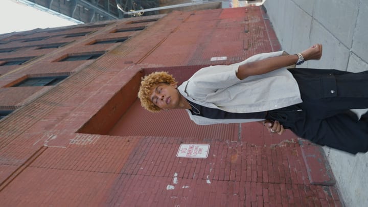 Young Person Leans Against Urban Brick Wall in NYC