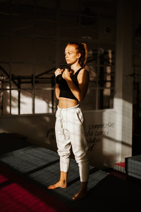 Focused Woman Prepares for Intense Parkour Session Indoors